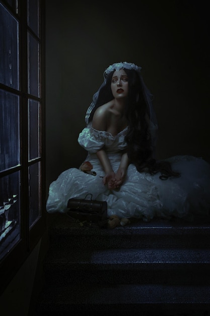 young woman crying while sitting by window at night
