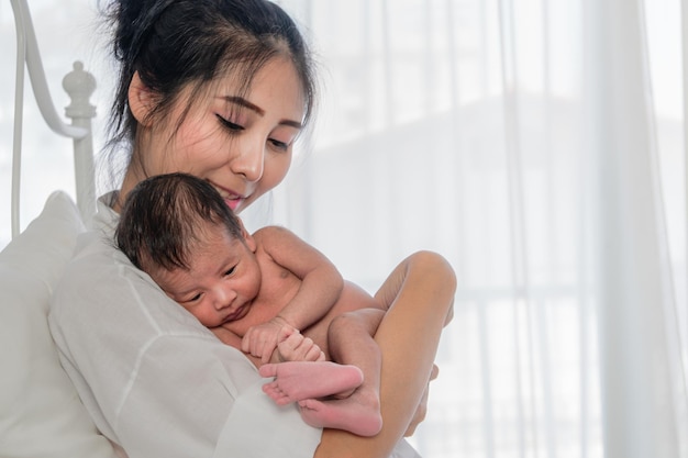 young woman holding baby boy at home