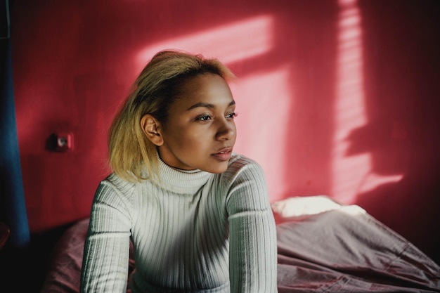 young woman sitting on bed