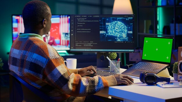 african american man using ai to develop a software system with chroma key on pc