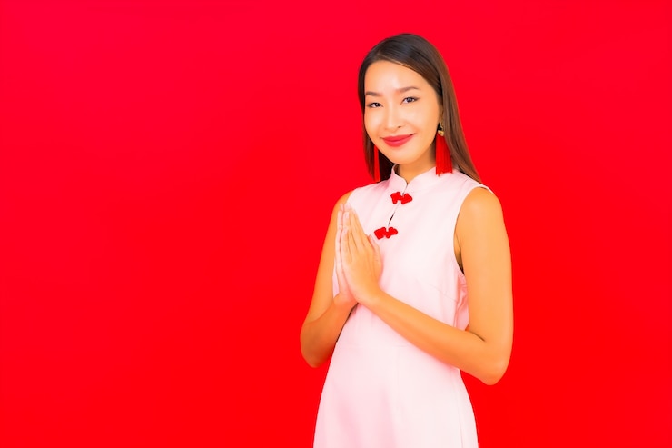 Miễn phí Photo ảnh chân dung người phụ nữ châu á trẻ đẹp mặc trang phục tết nguyên đán trên nền tường đỏ