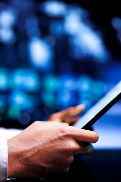 Certified serviceman resolving performance related issues in server hub. Technician utilizing mock up tablet to identify operational problems causing supercomputer slowdown
