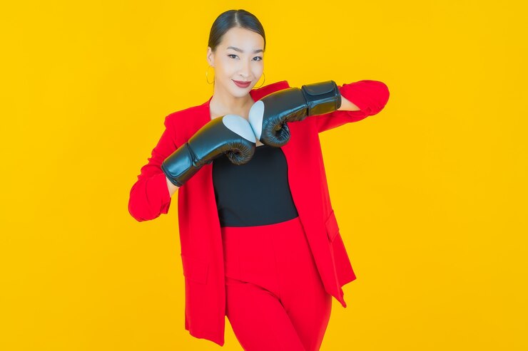 Miễn phí Photo chân dung người phụ nữ châu á trẻ đẹp với găng tay đấm bốc trên nền vàng
