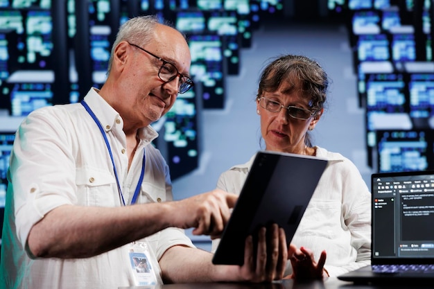 cloud computing business executives running analysis on supercomputers used for managing databases, hosting websites and storing files. precise experts auditing high tech server hub components