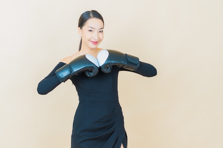 Miễn phí Photo cô gái châu á trẻ đẹp tập boxing với găng tay trên nền vàng