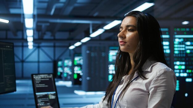 Computer scientist in data center monitoring security threats using computer