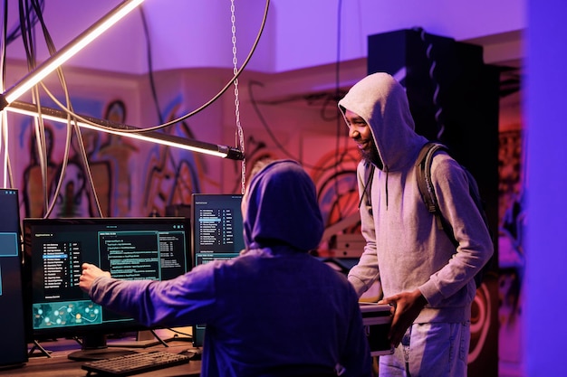 Hacker showing malware code on computer screen for data breach Criminals breaking law while programming internet virus malicious software and planning crime in hideout workspace