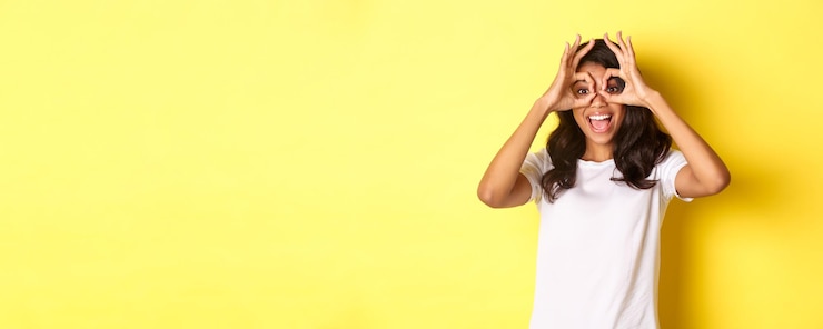 Miễn phí Photo image of happy and funny africanamerican girl making finger glasses and looking through them at some