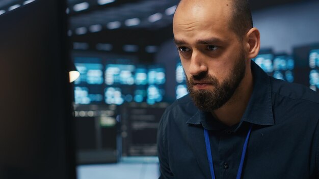 Overworked engineer feeling stressed while coding in data center