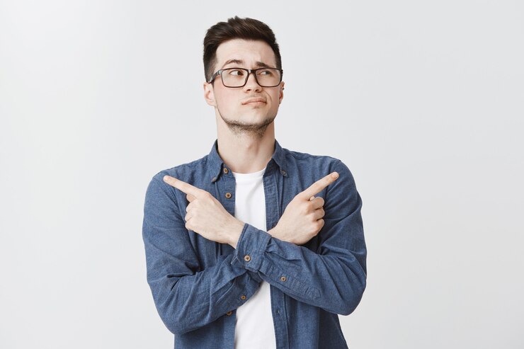 Miễn phí Photo perplexed man in glasses making decision, pointing fingers sideways