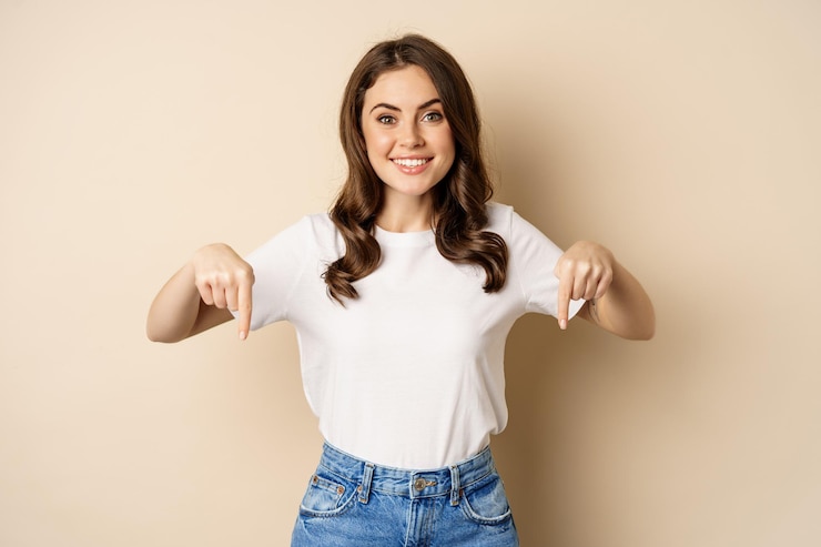 Miễn phí Photo smiling happy girl pointing fingers down and showing banner, company logo below, click link, standing over beige background