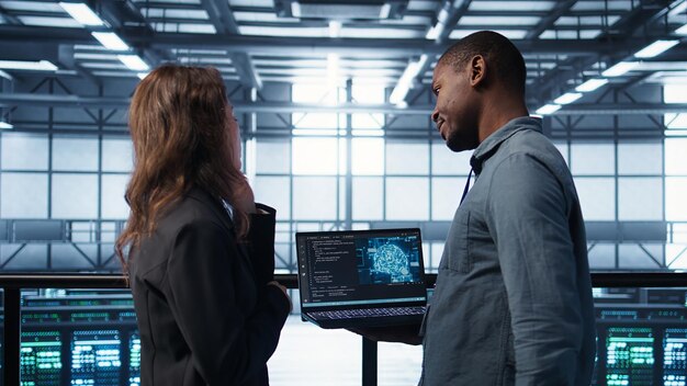 Software developers in data center using laptop employing AI machine learning