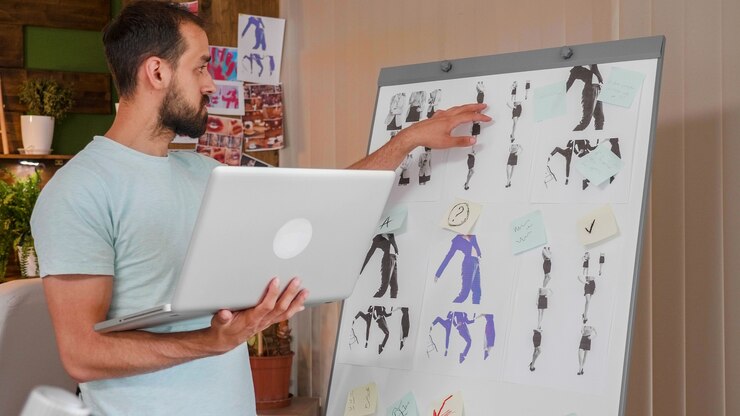Miễn phí Photo young designer working on whiteboard and holding a laptop. creativ agency