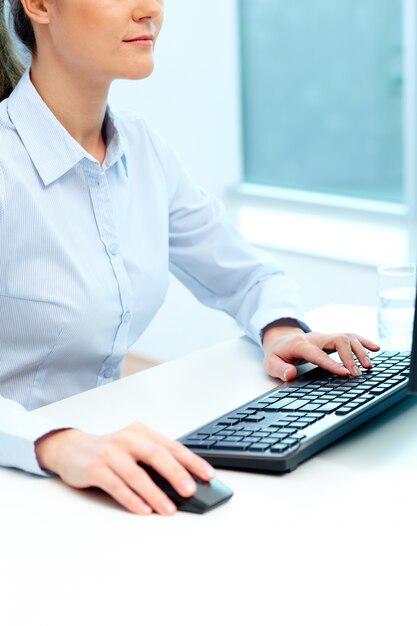 Businesswoman using computer and typing on keyboard