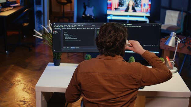 Computer scientist at home office desk writing binary code and drinking coffee