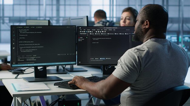 Developer typing code on PC to mend data center racks