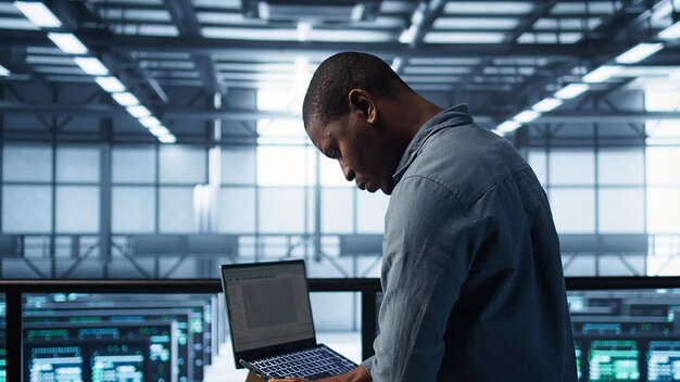 Engineer in data center operating notebook deploying new server architectures