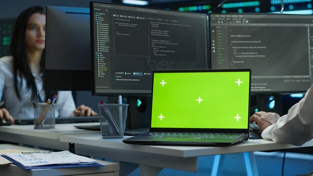 Expert in server room coding on chroma key notebook
