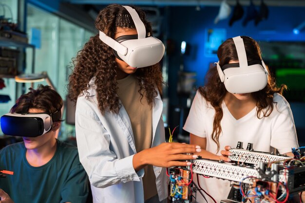 Group of young people in VR glasses doing experiments in robotics in a laboratory Robot on the table