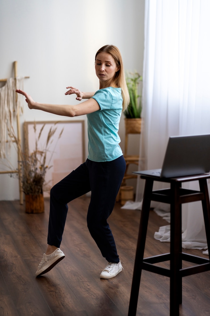 Ilmainen Kuva henkilö harjoittelee tai chi -liikkeitä sisätiloissa.