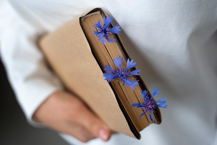 Ilmainen Kuva model holding book with flowers high angle