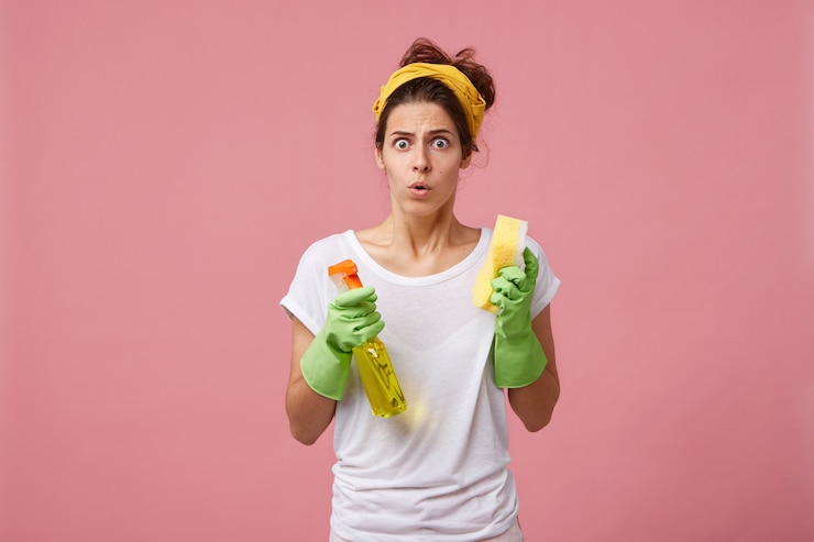 Ilmainen Kuva portrait of stressed terrified young caucasian woman dressed casually feeling panic while has to clean up rooms fast before guests come, holding cleanser spray and sponge in her hands