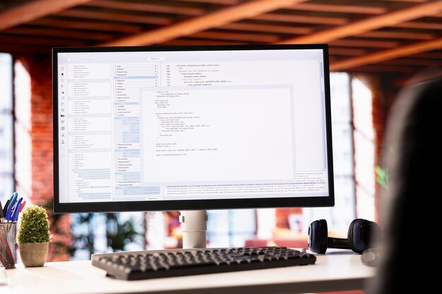 Programming code executing software UI on computer monitor in apartment office