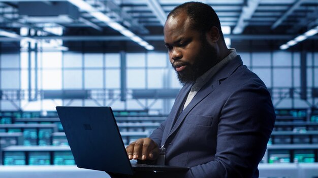 Software developer monitoring server hub hardware energy consumption with laptop