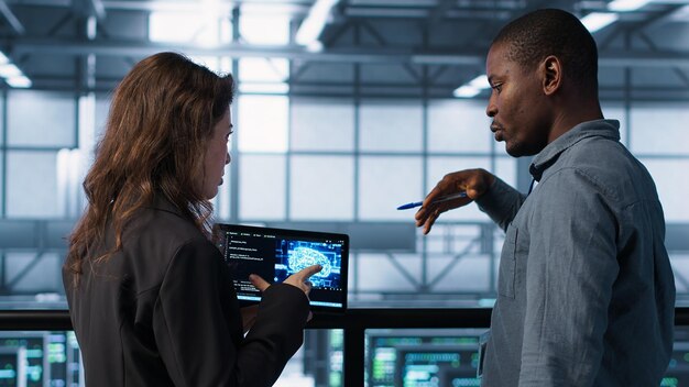 Software developers in data center use AI technology on tablet