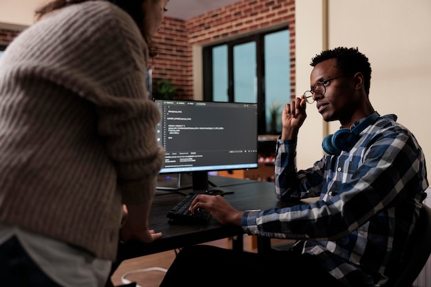 Software developers sitting at desk and developing a functional data encryption system. Multiethnic cyber security team members in agency office writing cloud database processing algorithm.