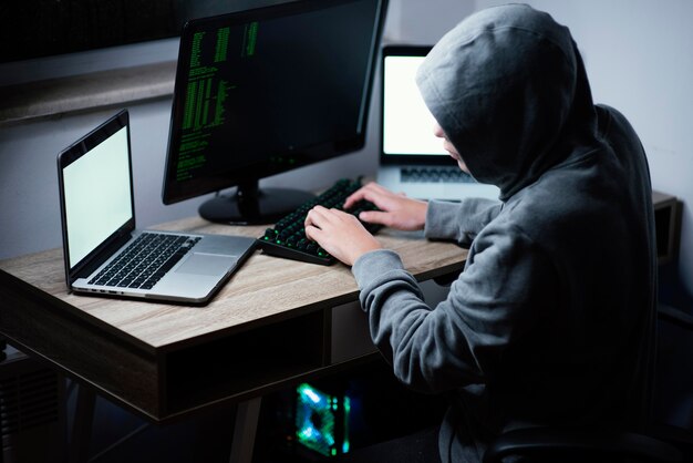 Teenager boy playing on computer and laptop