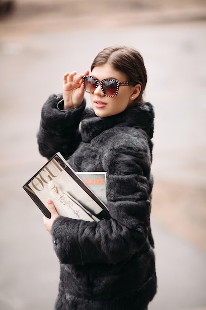 Photo gratuite 03 18 2019 biélorussie minsk femme branchée en manteau de fourrure et lunettes de soleil posant dans la rue