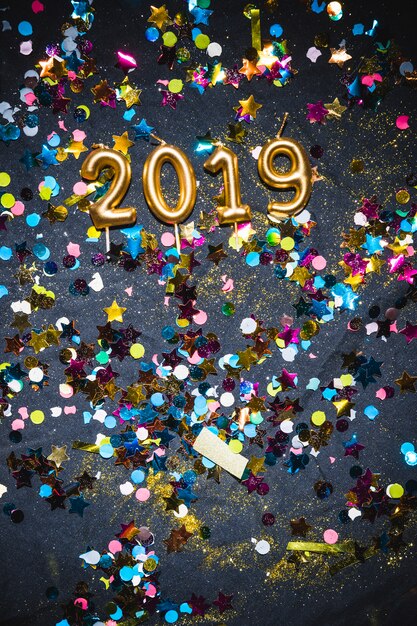 2019 bougies entre confettis multicolores