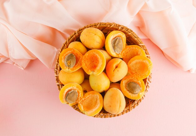 Abricots dans un panier en osier. pose à plat.