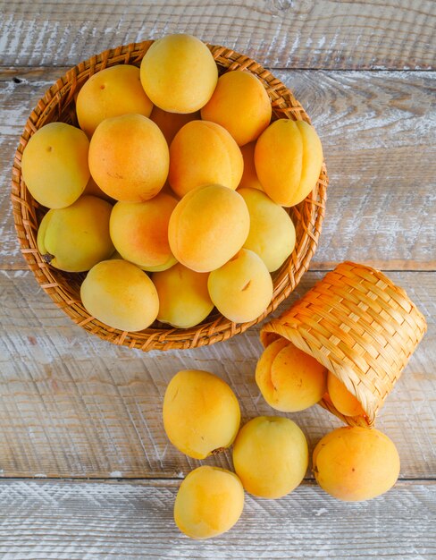 Abricots dans des paniers en osier sur une table en bois. vue de dessus.