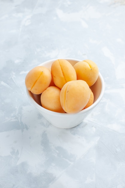 Abricots sucrés frais fruits moelleux et délicieux à l'intérieur de la plaque sur un bureau blanc, vitamines de repas de fruits frais d'été