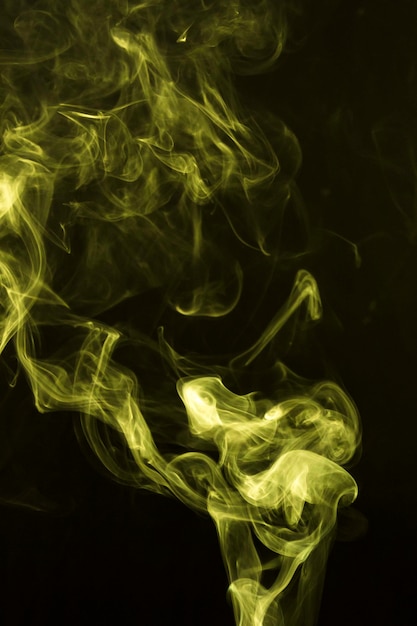 Abstrait jaune soufflant de la fumée sur fond noir