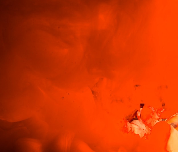 Abstrait orange dense agitant la fumée