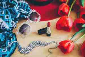 Photo gratuite accessoires de femme et tulipes rouges sur table