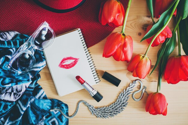 Accessoires de femme et tulipes rouges sur table