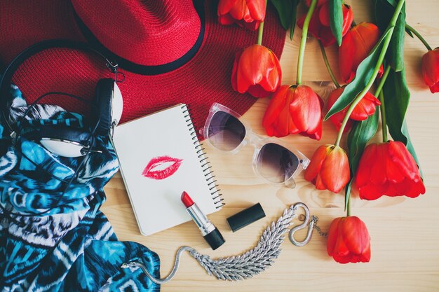 Accessoires de femme et tulipes rouges sur table