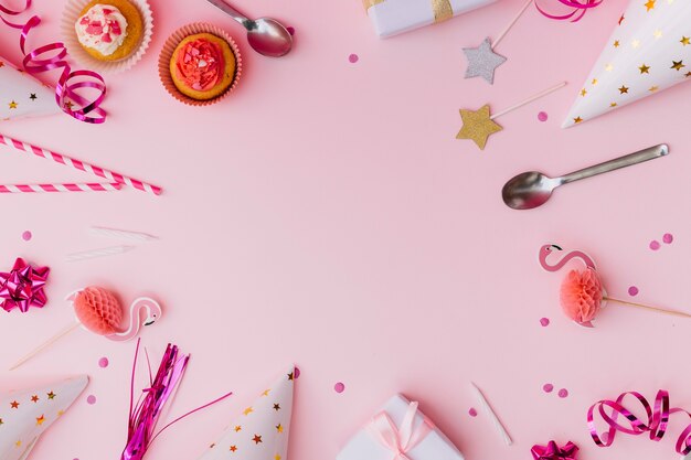 Accessoires de fête avec cupcake et cuillère sur fond rose