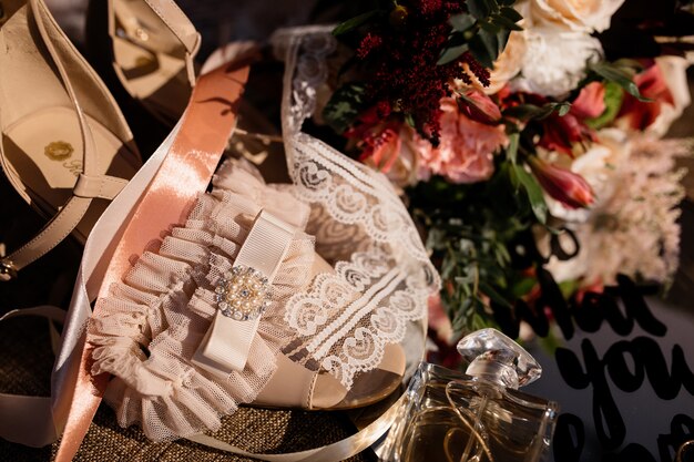 Accessoires de mariage tendre pour la mariée et le bouquet de mariage sur la journée ensoleillée