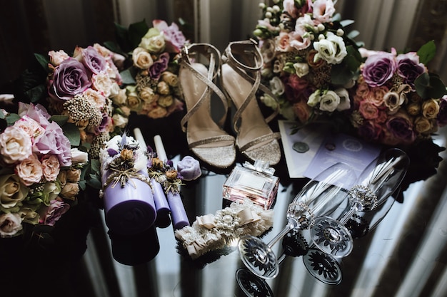 Accessoires de mariée de mariage dans des couleurs roses et violettes, verres de champagne de cérémonie, bouquets de mariage pour les mariées