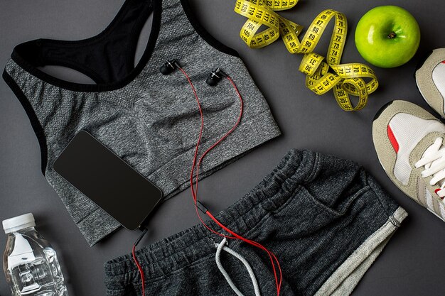 Accessoires de sport pour le fitness sur le sol sombre. Concept de mode de vie sain. Vue de dessus.
