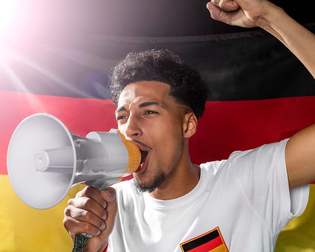 Acclamations de l'homme parlant dans un mégaphone avec drapeau allemand