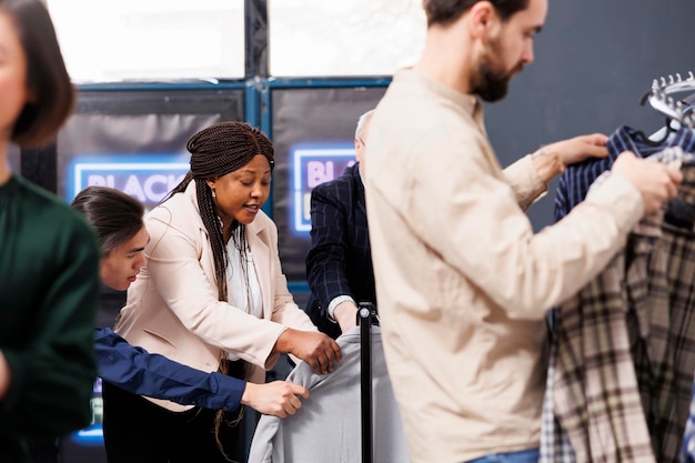 Photo gratuite les acheteurs frénétiques du black friday se disputent des vêtements dans un magasin de mode, les gens se disputent en faisant leurs achats pendant les soldes saisonnières. des clients diversifiés se précipitent pour de bonnes affaires, à la recherche de réductions