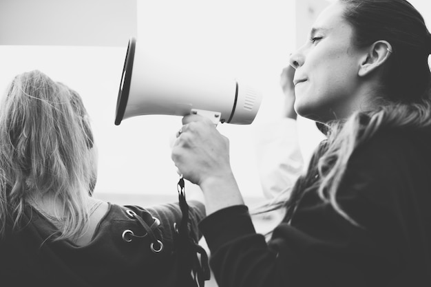 Photo gratuite activiste féminin criant sur un mégaphone