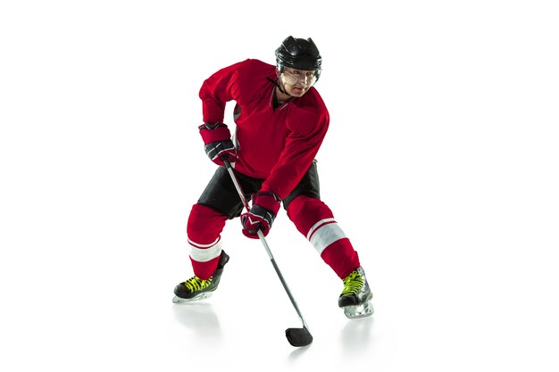 Activité. Joueur de hockey masculin avec le bâton sur un court de glace et un mur blanc. Sportif portant de l'équipement et un casque pratiquant. Concept de sport, mode de vie sain, mouvement, mouvement, action.