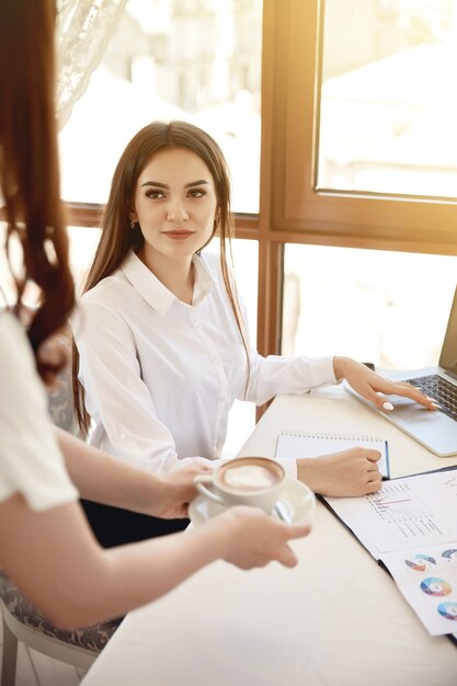 Administratrice brune d'un restaurant sur son lieu de travail obtient un latte